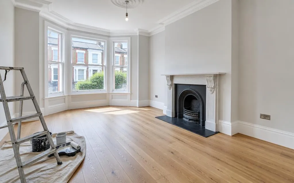 Freshly refurbished living room with new flooring and a restored period fireplace